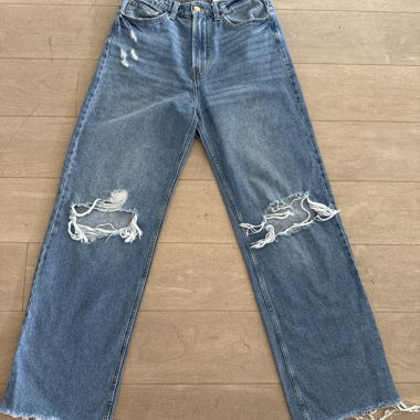 Lange gelochte blaue Jeanshose