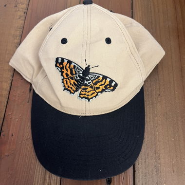 Casquette beige et noire avec papillon