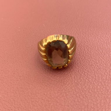 Goldfarbener Ring mit dunklem Stein