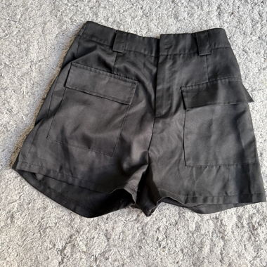 Short nero vita alta con passanti per cintura, pinces sul davanti e due grandi tasche cargo con patta sul retro.
Tessuto molto leggero