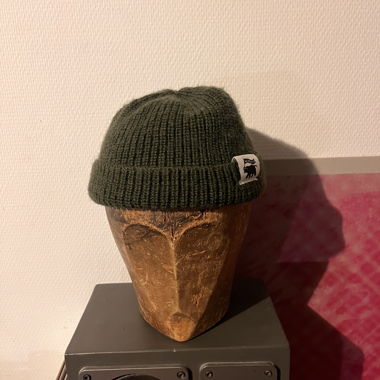 Dunkelgrüne Strickmütze mit Aufnäher