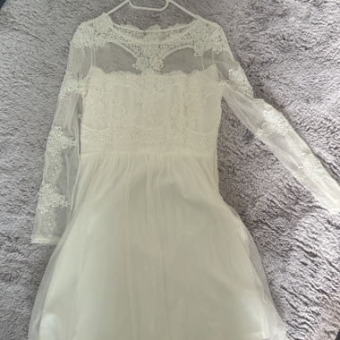 Abito bianco in pizzo con maniche lunghe