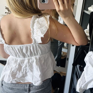 Top bianco smanicato con volant