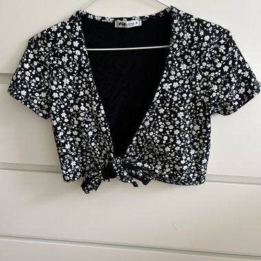 Top corto nero con fiore e nodo