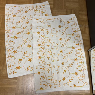 Set mit weissen dekorativen Teppichen mit orangefarbenen Mustern