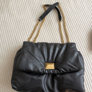 Schwarze gesteppte Handtasche mit goldener Kette