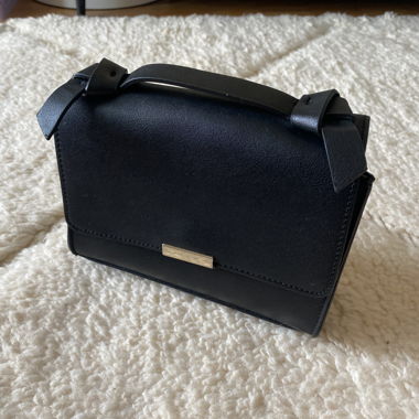 Schwarze Handtasche mit Griff und Goldkette