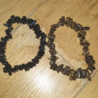 Armbänder aus schwarzen und braunen Perlen mit Kristallsteinen