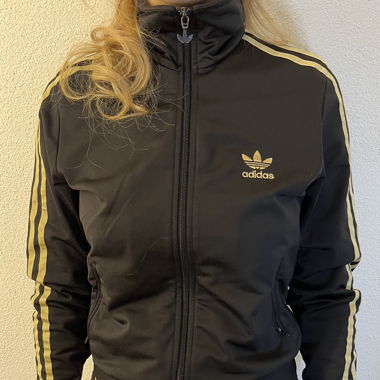 Adidasjacke mit goldenen Streifen