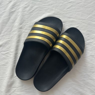 Schwarze und goldene Adidas Slides
