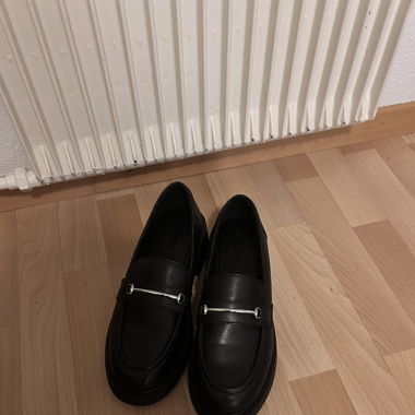 Black leather loafers with a preppy vibe 