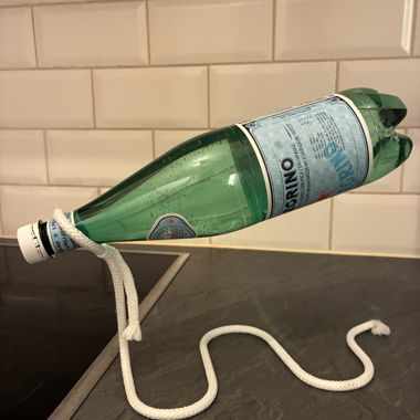 Portabottiglie decorativo a forma di corda bianca rigida, che crea un effetto di levitazione per una bottiglia di vino o d'acqua.