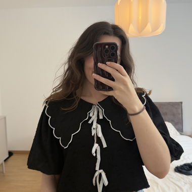 Schwarzes Top mit Volantkragen und Details