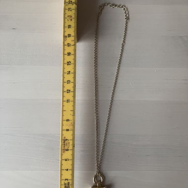 Gold-colored necklace with green stone square pendant in silver