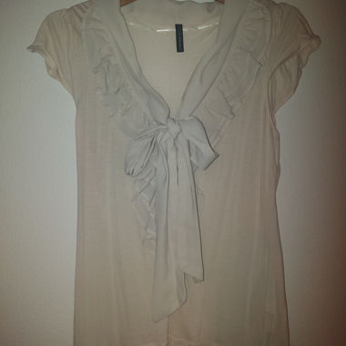 Blusa beige con volant e fiocco