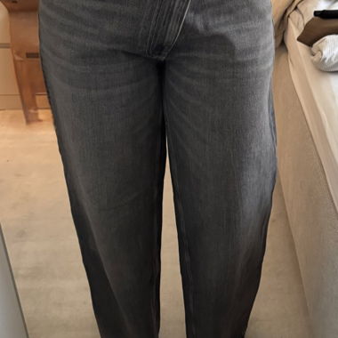 Jeans grigie a gamba larga con vita asimmetrica
