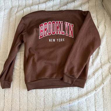 Brauner Pullover mit Aufschrift vorne