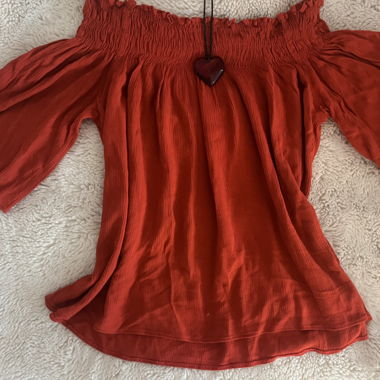 T-shirt arancione che cade sulle spalle