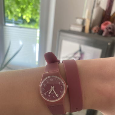 Uhr der marke Swatch in dunkelrosa