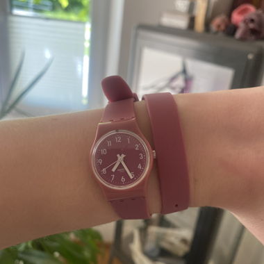 Uhr der marke Swatch in dunkelrosa