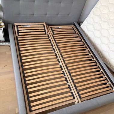 Graues Polsterbett mit Lattenrosten