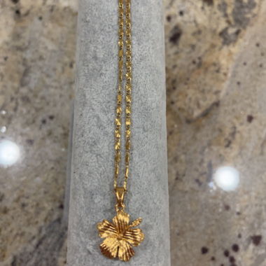 Gold-colored necklace with hibiscus pendant