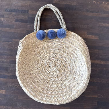 Borsa rotonda in paglia con pon-pon