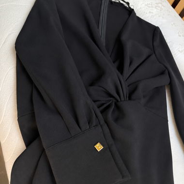 Schwarzes Wickelkleid mit Golddetails