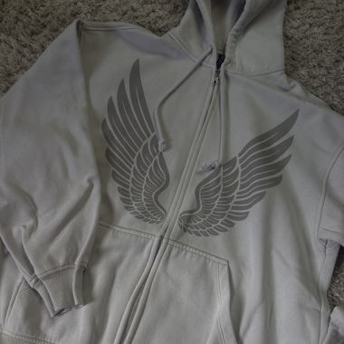 Veste à capuche grise zippée avec imprimé d’ailes