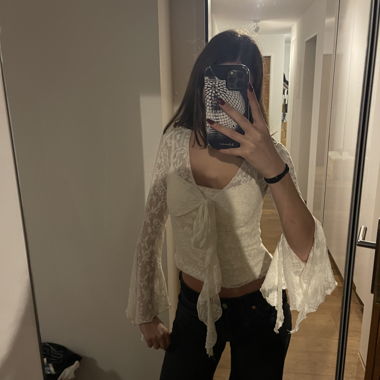 Top in pizzo con maniche a campana e laccio frontale