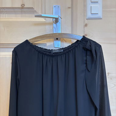 Blouse noir avec noeud sur l’épaule gauche